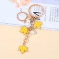 Rose gold maple leaf keychain with yellow charms and faux pearls for bag decor. - 黄色珍珠款式