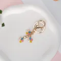 Gold-plated metal keychain featuring three colorful enamel flower pendants for handbags - Multicolor With Lobster Clasp