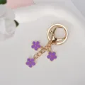 Exquisite gold metal keychain featuring three purple enamel flower charms for bags - Purple With Lobster Clasp