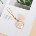 Detail view of a cute enamel rabbit charm with pink cherry blossoms and a tassel. - Tassel Cherry Blossom Rabbit