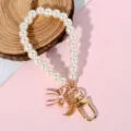 Elegant faux pearl phone lanyard featuring a pink enamel bow and crescent moon charm - Pink Bow & Hollow Moon Style (Style 8)