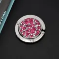 Bovenaanzicht van een opvouwbare handtashaken met roze en zilveren glanzende steentjes - Glinsterende Strass Stijl / Roze Zirkonia