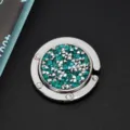 Detailweergave van ronde opvouwbare tashanger met fonkelende blauwe en zilveren strass - Glinsterende Strass Stijl / Blauwe Zirkoon