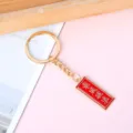 Metal inspirational keychain featuring a red pendant with gold Chinese characters - Rectangle Ride the Waves
