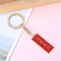 Red enamel metal keychain with embossed Good Luck blessing and gold-plated hardware - Rectangle Blessed by Luck