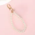 Elegante witte parelkoord met gouden karabijnsluiting voor telefoon of handtas decor - Witte kralenketting