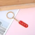 Red enamel keychain with smooth sailing blessing and gold-tone metal ring - Oval Smooth Sailing