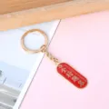 Inspirational red and gold metal keychain featuring traditional exam success blessing - Oval Success in Exams