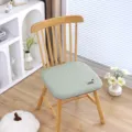 Detailaufnahme eines hellgrünen karierten Memory-Foam Stuhlkissens mit niedlicher Hunderstickerei. - Grün