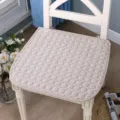 Gros plan détaillé du coussin de chaise matelassé beige avec motif rond dans la scène. - Beige uni antidérapant matelassé