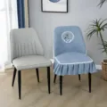 Detailed view of a quilted dining chair cover with deer embroidery and lace ruffles for decor. - Always with You Grey