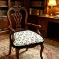 Detail view of the vintage wooden armchair featuring a botanical print cushion with black fringe. - 40*43 cm / Overlapping Shadows Off-White Cushion