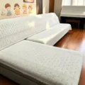Gedetailleerd overzicht van de gewatteerde bankhoes met elegante schulprand en fijn bladerpatroon. - 1m*1m / Gouden tak en jade blad beige