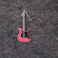 Detailed macro view of a pink electric guitar keychain on a grey textured background - Pink
