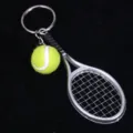 Detalle del llavero de mini raqueta de tenis con accesorio de pelota de tenis amarilla. - Plateado