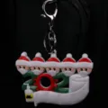 Detalle de primer plano del llavero navideño 2021 con personajes con mascarillas - Familia de Cinco