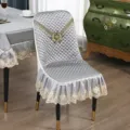 Detailansicht des luxuriösen gesteppten Esszimmerstuhlbezugs mit eleganter goldener Spitzensticke. - Päonienblüte geschwungen Grau