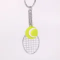 Detalle de un llavero con mini raqueta de tenis y pelota amarilla flúor - Verde