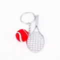 Mini silver-colored metal tennis racket and red fuzzy ball keychain set detail view - Red