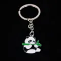 Detailed close-up of a cute cartoon panda keychain eating bamboo with silver metal ring - 熊猫09款式