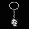 Close-up of cute cartoon panda enamel metal keychain pendant on black background - 熊猫04款式