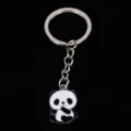 Close-up of a cute panda enamel metal keychain on a black background - 熊猫03款式