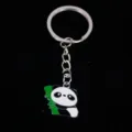 Detailed macro view of a cute metal panda charm with green bamboo on black background. - 熊猫01款式