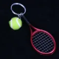 Primer plano de un llavero con mini raqueta de tenis roja y pelota de tenis amarilla - Rojo