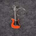 Vista detallada de un llavero con forma de guitarra eléctrica naranja sobre fondo gris - Naranja