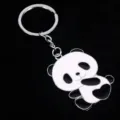Gedetailleerd overzicht van een schattige metalen panda-sleutelhanger met zwart-wit emaille - Zijwaarts Liggende Panda