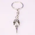 Macro detail of a silver gothic bird skull pendant attached to a sturdy metal keychain - Bird Skull Style (1)
