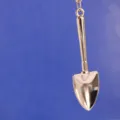 Imagen detallada de un llavero miniatura de metal plateado pulido en forma de pala. - Estilo Pala (16)