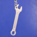 Detalle de un llavero de metal plateado pulido con forma de llave sobre fondo azul - Estilo Llave Fija Hexagonal (4)