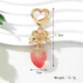 Sweet strawberry keychain with gold bow and heart clasp showing dimensions 7.5cm by 2cm - UV Red