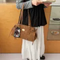 Klassische braune Wildleder-Baguette-Tasche mit Ziernähten und goldenem Schild - Mit Katzenkartenhalter-Anhänger / Braun