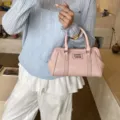 Chic pink woven textured tote handbag for women featuring top handles and logo detail - Pink
