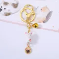 Close-up of ceramic mouse zodiac keychain with golden bell and tanuki coin charm detail - Mouse