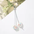 Detalle de los colgantes blancos con forma de corazón y cubo smile en un llavero plateado. - Sonrisa Ojo Corazón