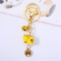 Close-up of a cute yellow ceramic zodiac tiger keychain with golden bells and pendant. - Tiger