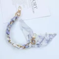 Detail view of elegant floral silk scarf phone chain with dual gold lobster clasps - Style T