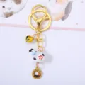 Close-up detail of cute ceramic cow keychain with golden bell and Chinese zodiac charm - Cow