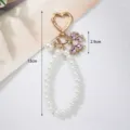 Detailed view of handmade pearl bow keychain with dimensions of 13cm and weight 28.7g - Pink