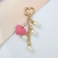 Vue détaillée d'un porte-clés à la mode avec cœur rose, perles blanches et fermoir doré - Rose