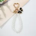 Close-up of handmade faux pearl keychain with black rhinestone butterfly charm - Black