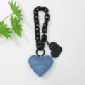 Detalle de colgante de corazón de cuero azul para bolso con cadena negra y relieve - Azul zafiro