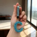 Close-up handheld view of a sparkling blue rhinestone letter C keychain with matching strap - Letter C