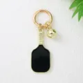 Gros plan sur un élégant porte-clés raquette de pickleball noir et or avec charme - Noir