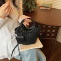 Black woven bucket bag with round top handles and crossbody strap - Black