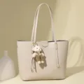 Elegant beige solid color large capacity tote bag featuring a cute bear keychain accessory - Off White
