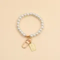 Close-up of pearl bead keychain with gold Elizabeth II pendant and lobster clasp. - Queen Pearl Chain (037-3)